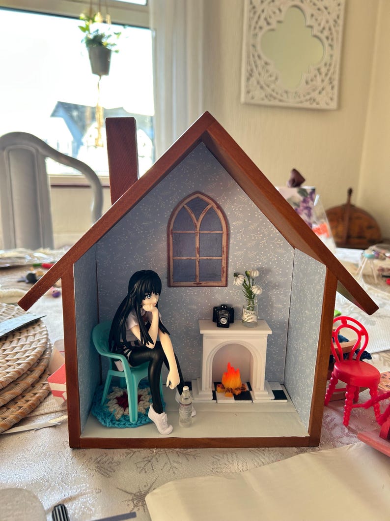 scene on a shelf Anime doll sitting casually by fireside or coffee table scene.